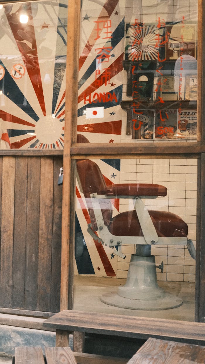 Cozy vintage barber shop showing red chair and retro decor through the window.