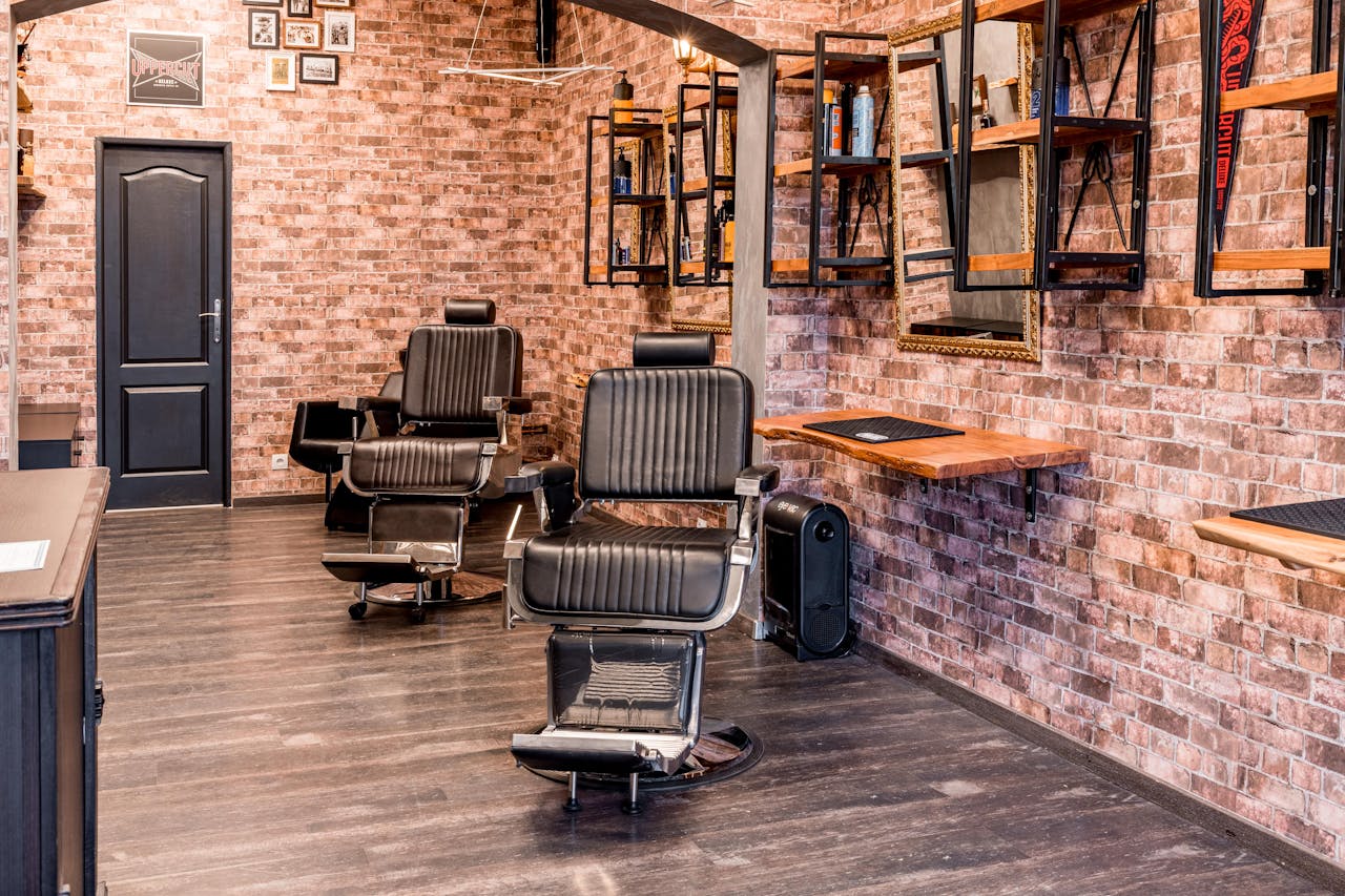 Stylish barber shop interior featuring black leather chairs and rustic brick walls for a contemporary look.